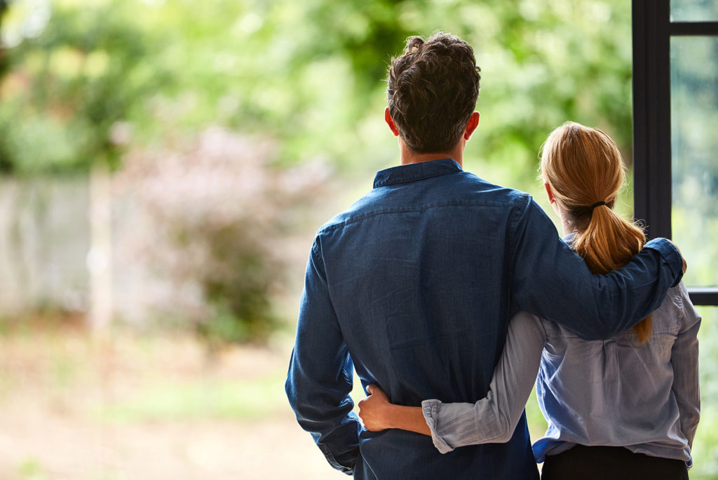 future plan couple looking out from new home