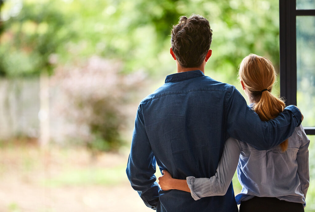 future plan couple looking out from new home